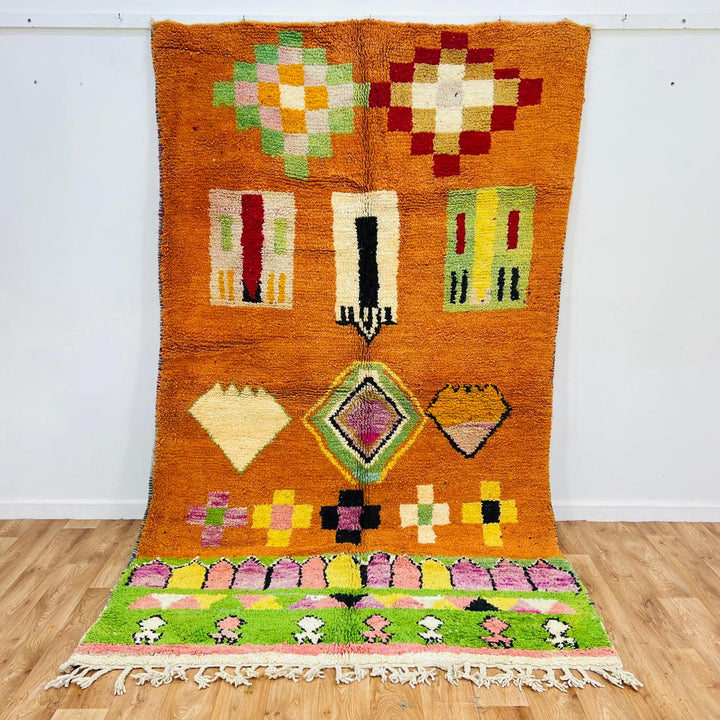 Vintage Moroccan wool rug with orange base and colorful Berber geometric patterns, handmade in Morocco