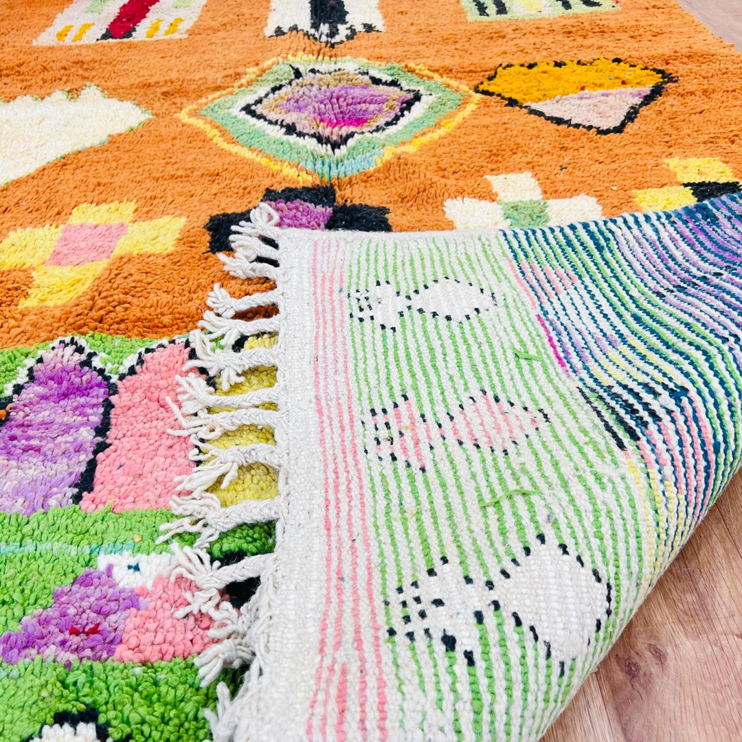 Vintage Moroccan wool rug with orange base and colorful Berber geometric patterns, handmade in Morocco