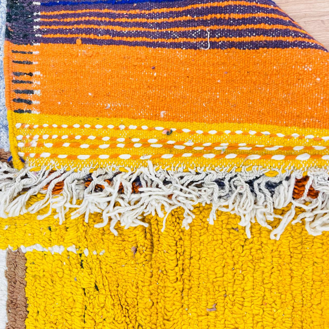 Vintage Moroccan wool rug with abstract geometric Berber design in mustard yellow, blue, and black, handmade in Morocco