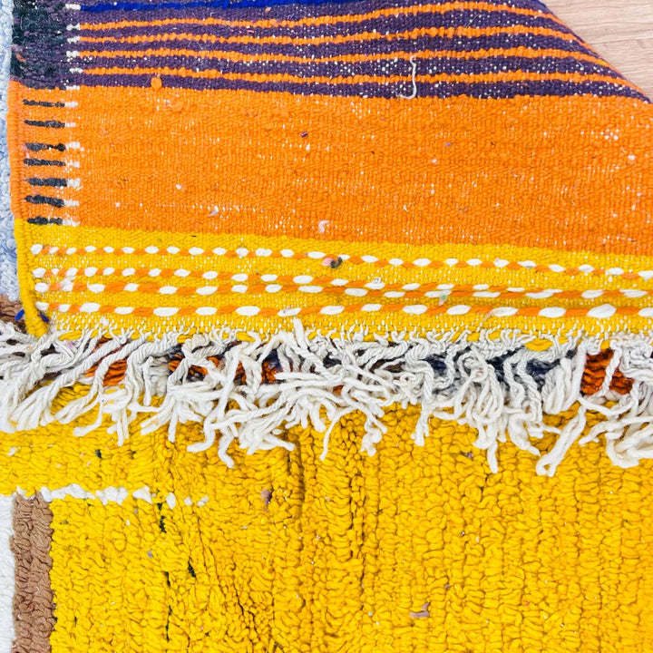 Vintage Moroccan wool rug with abstract geometric Berber design in mustard yellow, blue, and black, handmade in Morocco