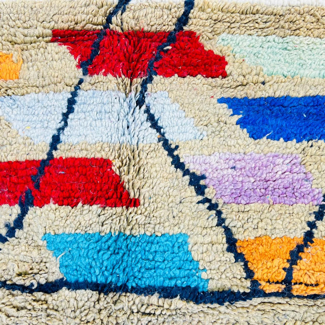 Vintage Moroccan Berber wool rug with ivory base, black tribal lines and colorful geometric accents