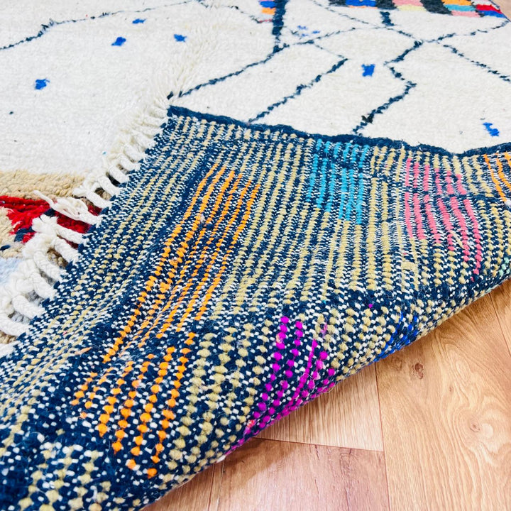 Vintage Moroccan Berber wool rug with ivory base, black tribal lines and colorful geometric accents