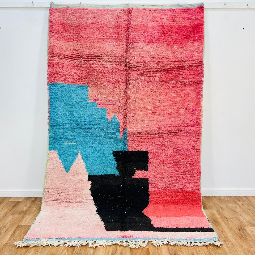 Vintage Moroccan wool rug with abstract coral pink, blue, and black color-block geometric design, handwoven Berber carpet from Morocco.