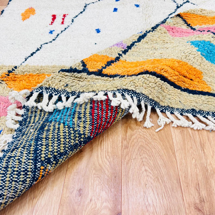 Vintage Moroccan Berber wool rug with ivory base, black tribal lines and colorful geometric accents
