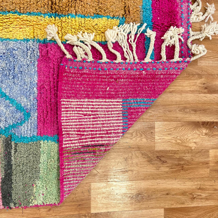 Vintage Moroccan wool rug with abstract Berber figure in turquoise and warm pink, sand and brown tones, handwoven in Morocco