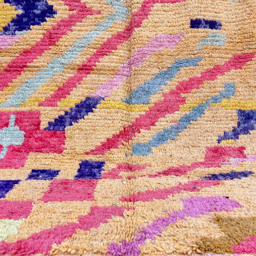 Vintage Moroccan wool rug with abstract geometric Berber design in warm ochre, pink, blue and green tones, handwoven in Morocco.