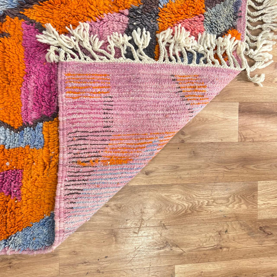Vintage Moroccan wool rug with abstract geometric Berber design in orange, pink, blue and gray tones, handwoven in Morocco.