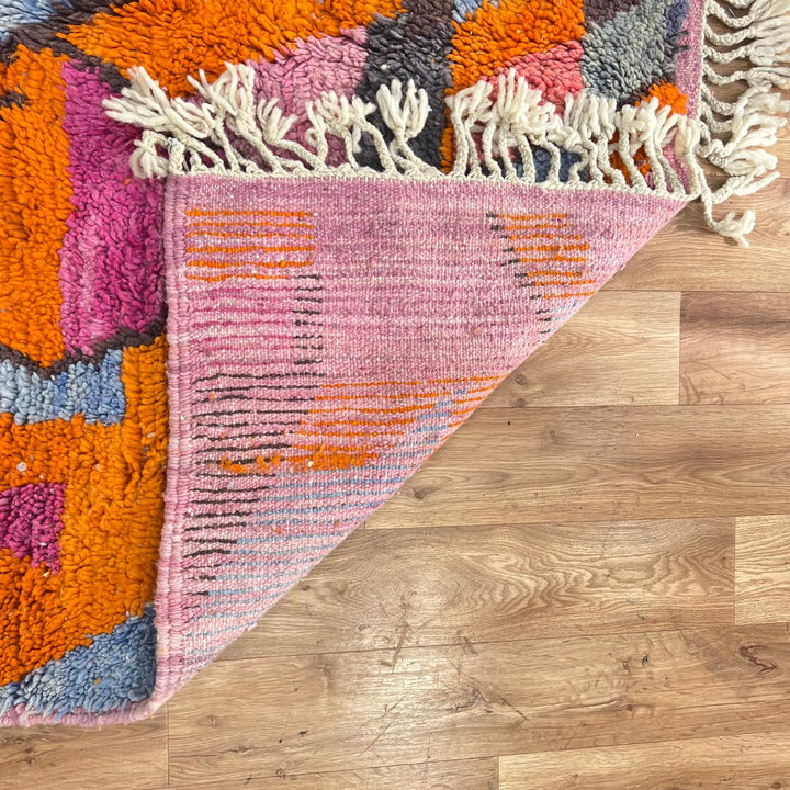 Vintage Moroccan wool rug with abstract geometric Berber design in orange, pink, blue and gray tones, handwoven in Morocco.